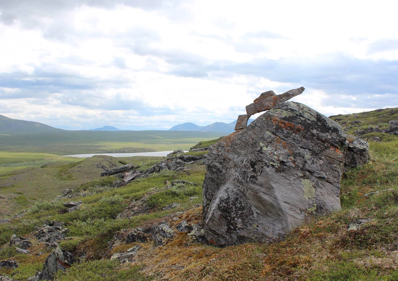 Inuksuk GAAR Upper Nigu Valley Caitlin Holloway Wide broad rocky valley. Smaller rocks have been built up on a large rock in the foreground