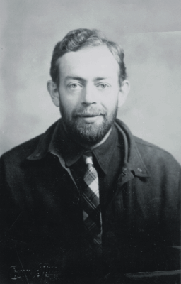 formal portrait, shoulders view, of a smiling bearded man