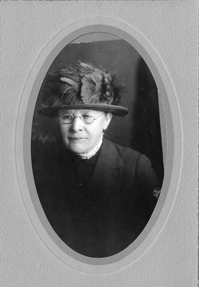 Shoulders portrait of an older woman wearing a flowery hat