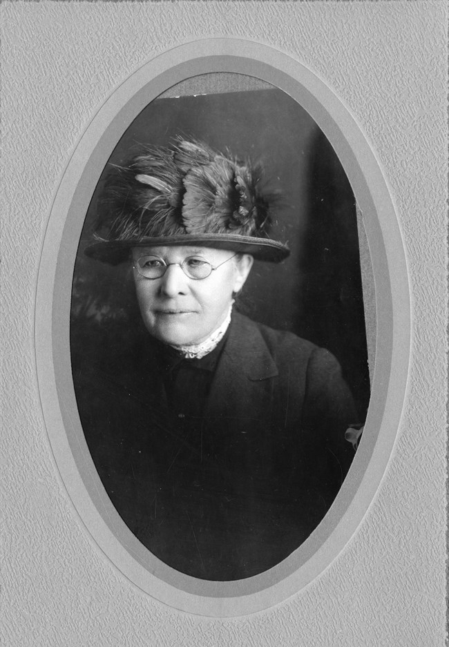 Nellie Cashman photographed in 1924 Shoulders portrait of an older woman wearing a flowery hat