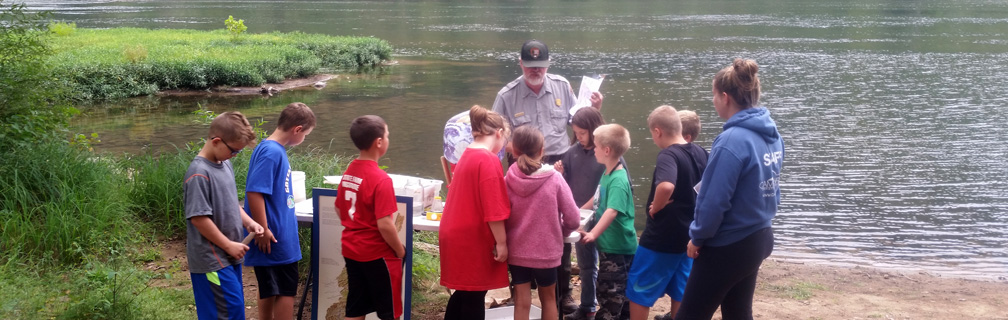 ranger with students alongside river