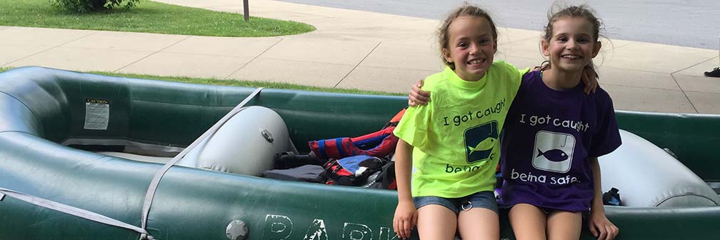two young girls standing next to a raft