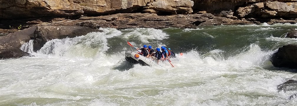 rafters paddle through big whitewater