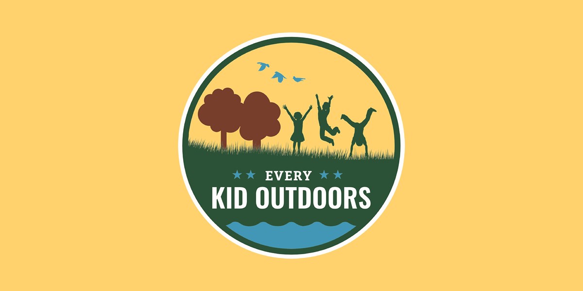 Silhouette of kids with trees and grass against yellow background