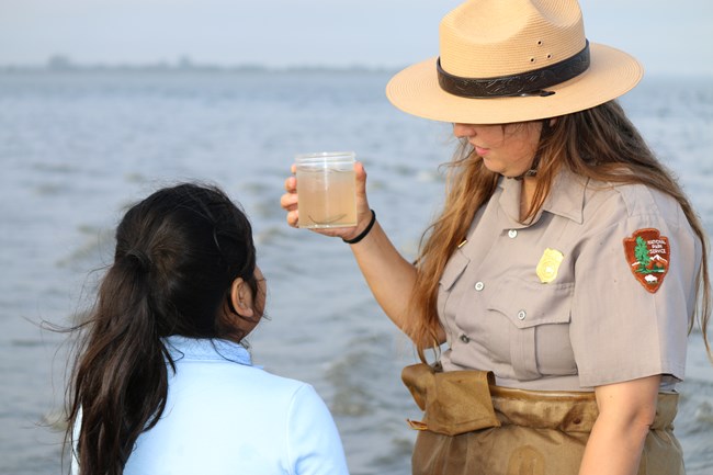 Ranger Audrey holding a jar containing fish