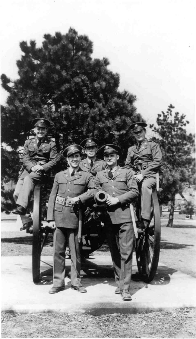 5 soldiers pose on one of Fort Hancock's salute guns
