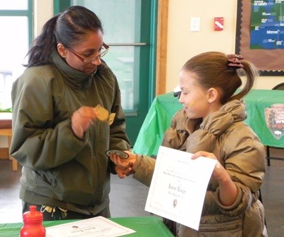 Park Guide Shalini Gopie awards a Junior Ranger badge during Junior Rangerpalooza at Great Kills Park. Park Guide Shalini Gopie awards a Junior Ranger badge during Junior Rangerpalooza at Great Kills Park.