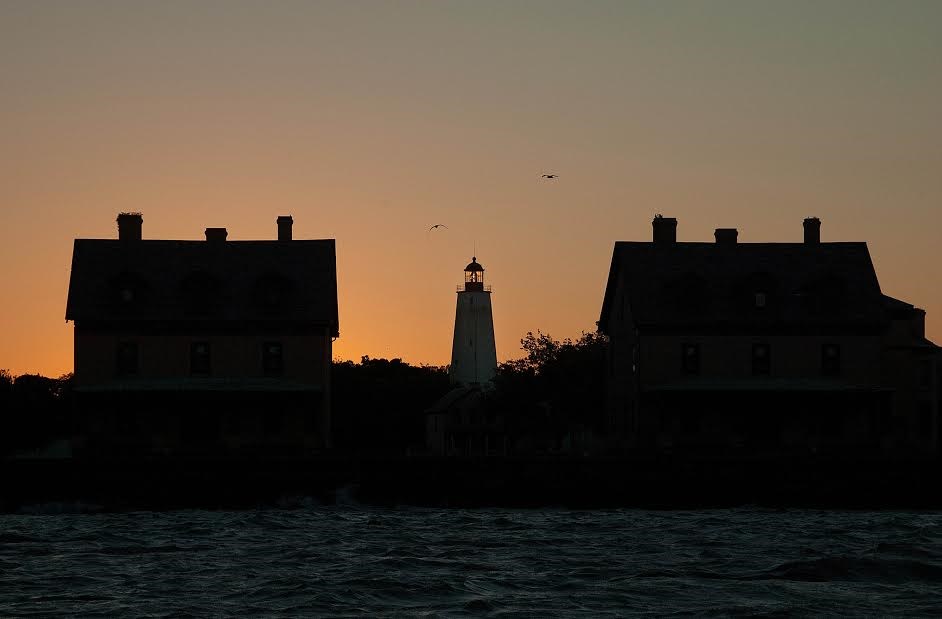 Two former officers' residences at Fort Hancock Historic Post frame the Sandy Hook Lighthouse at sunrise. Photo by Volunteer-in-Park Stanley Kosinski.