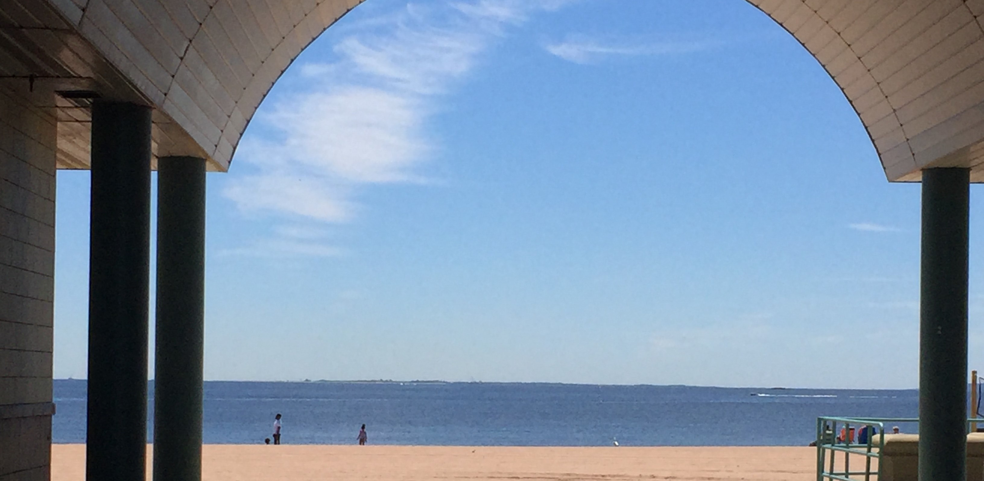 Beach through Entrance Beach seen through arched entrance of building