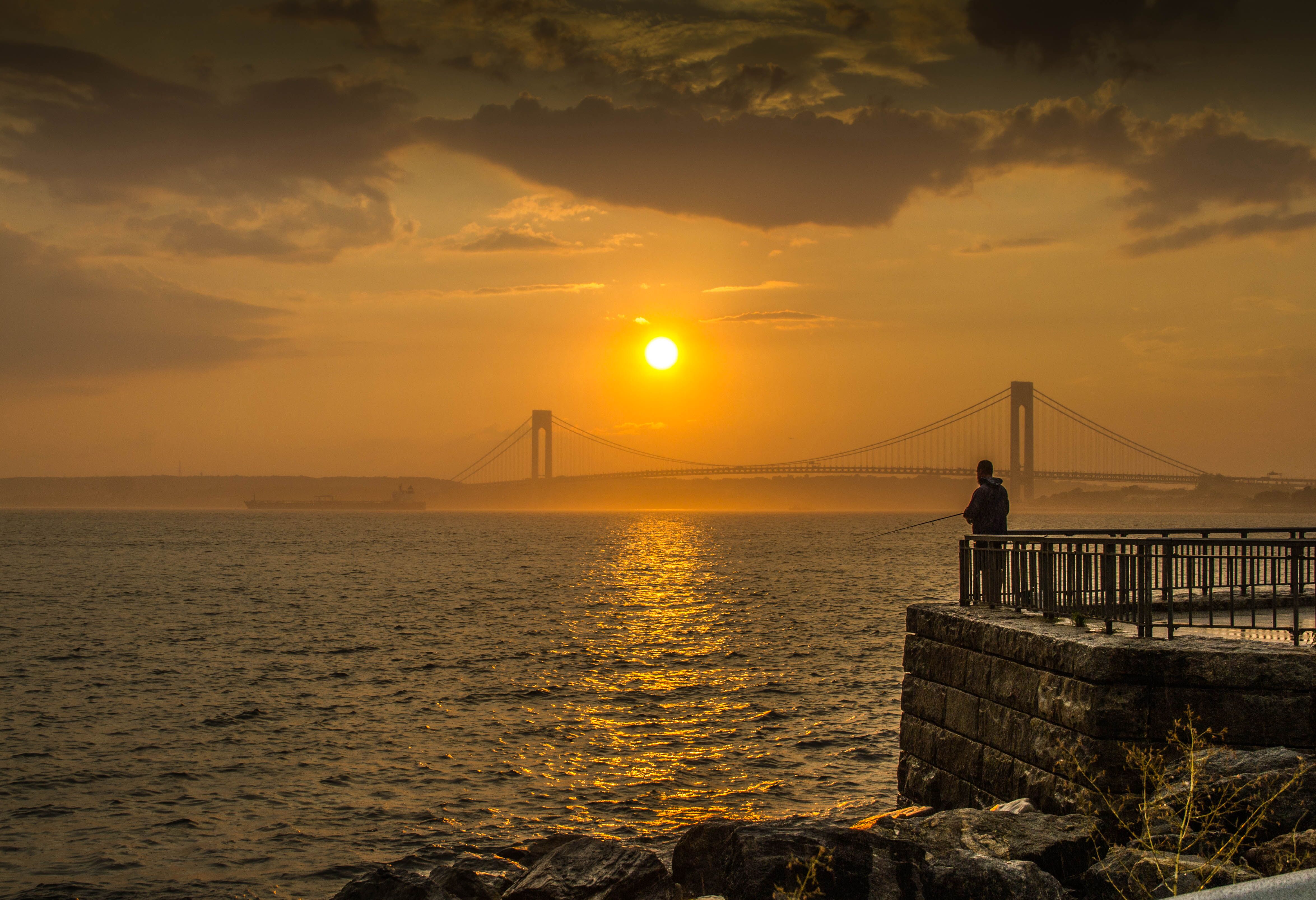 Solitude opening_Jashari Solitary man fishing with Verrazzano Narrows Bridge in the background