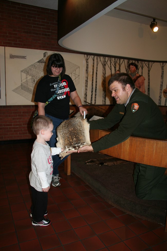 Ranger showing an animal fur to a young visitor