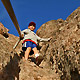 youth on steep trail holding rope