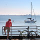 bicyclist looks toward ship on water