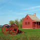 small, red, one-room building with red cannon in foreground
