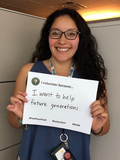 NP Week volunteer Woman holding sign saying I volunteer because I want to help future generations.