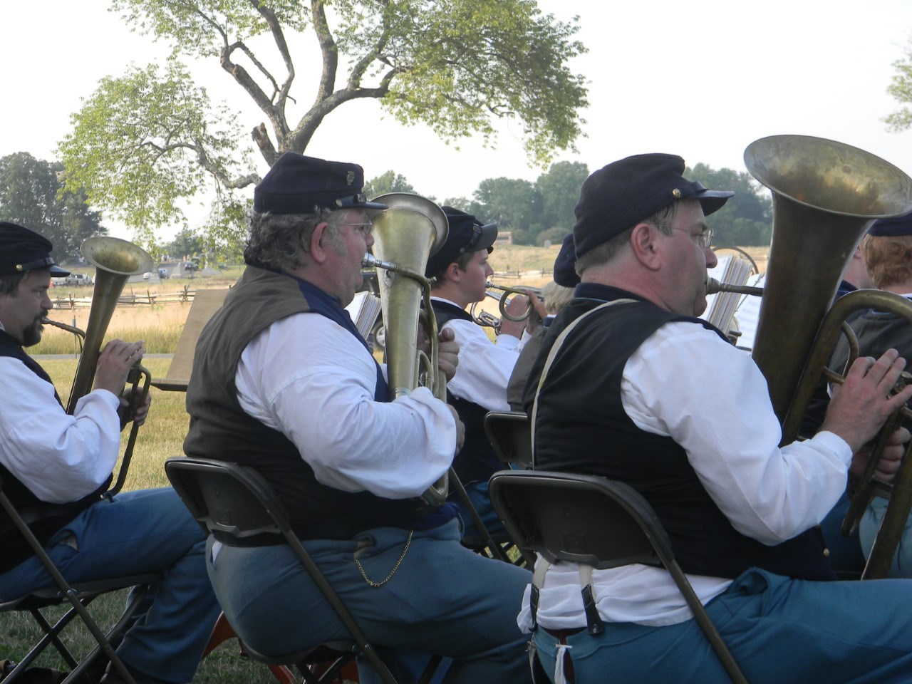 Musicians wearing Civil War soldier uniforms play brass instruments