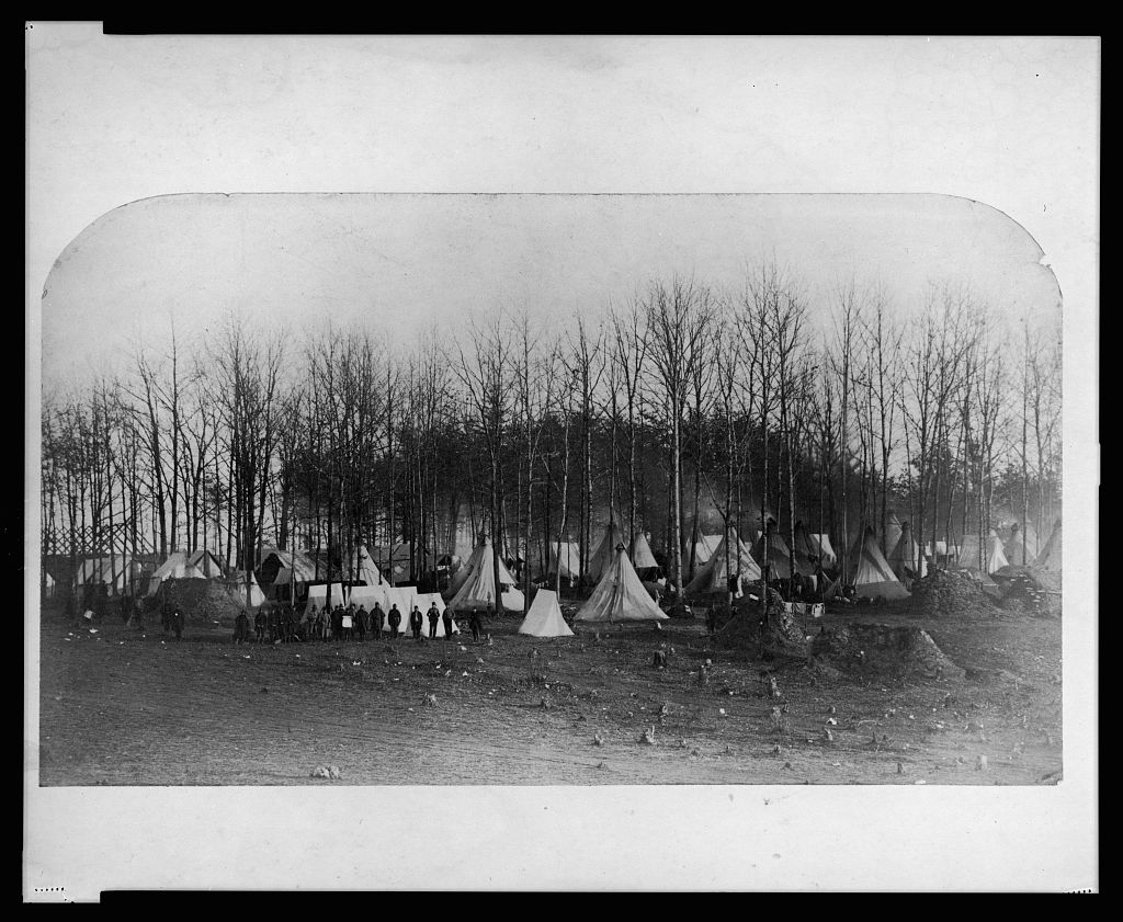 Camp of 2nd Vermont Volunteers at Camp Griffin, Virginia; large white tents are amongst trees while the wooden frame of a larger building is under construction
