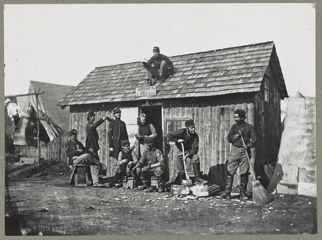 Pine Cottage, Civil War Soldiers in Winter Quarters; some are on the rooftop others lounge around in front of cabin