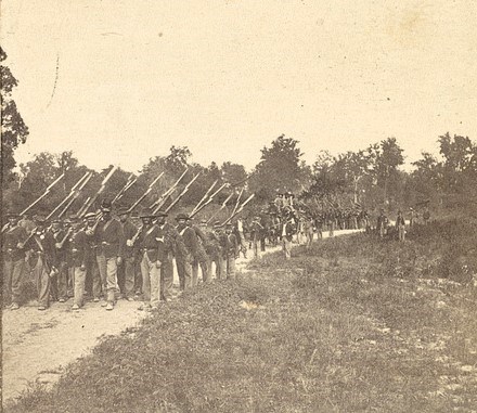 134th Illinois Soldiers On The March Photograph showing Civil War Soldiers of the 134th Illinois Infantry On The March; the soldiers are carrying rifles with bayonets attached.