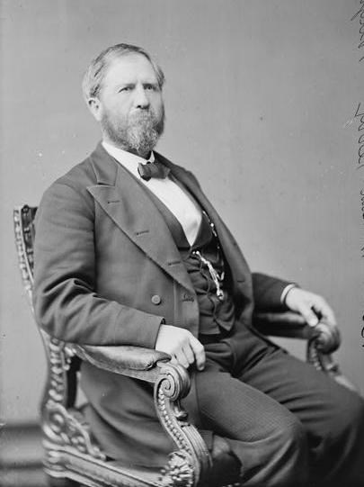 A bearded man sits in a chair