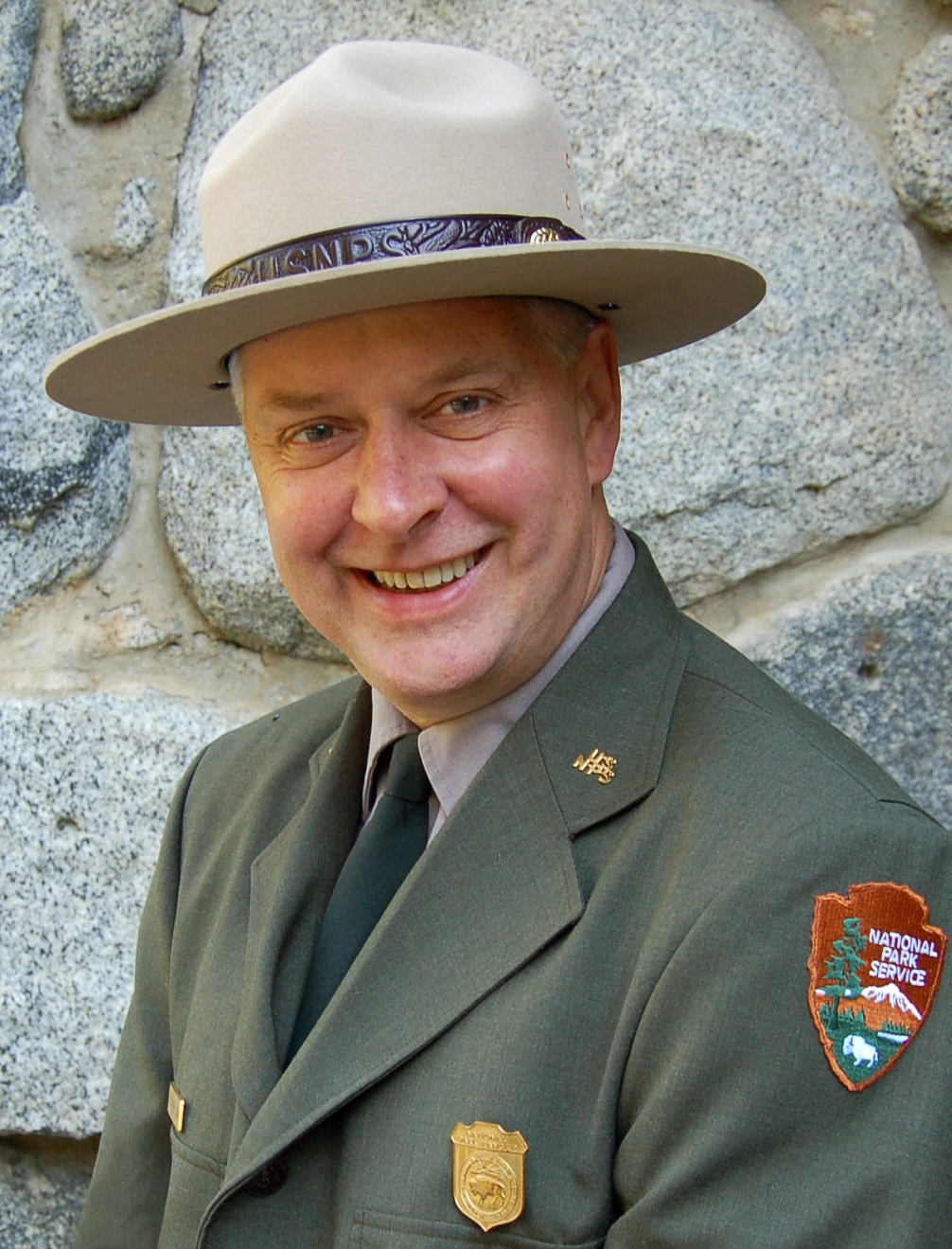 Acting Superintendent Chris Stein stands in front of a stone wall.