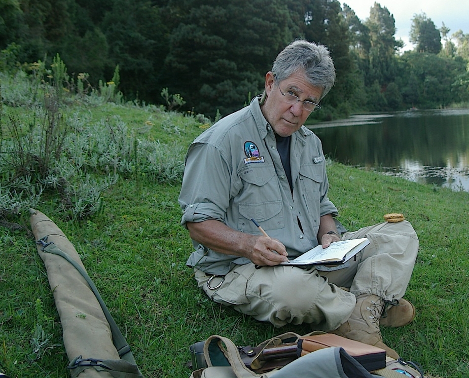 Chip Beck sits on the bank of a river in Kenya.