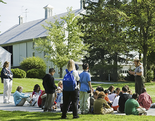 A park ranger talks to a group of school children.