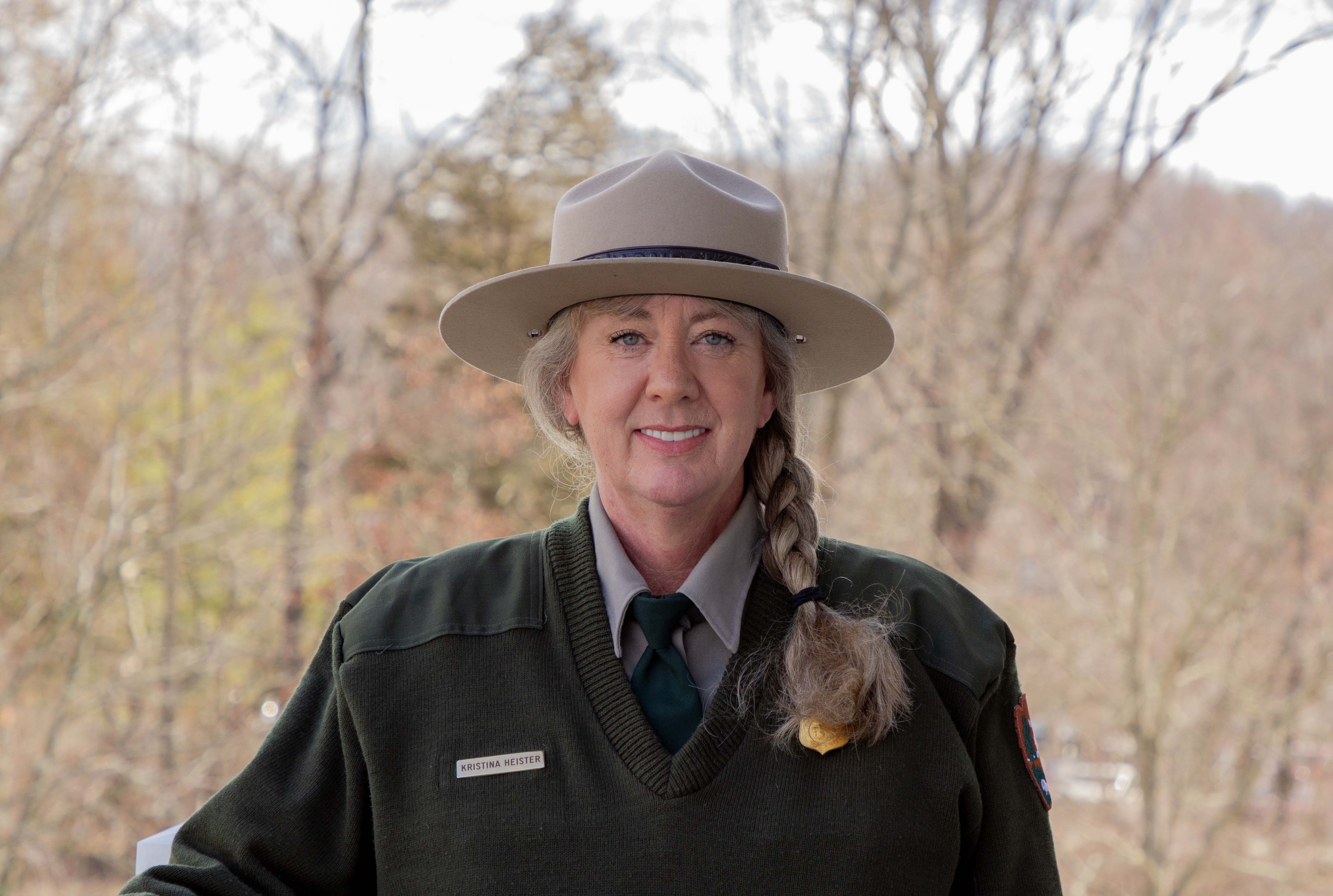 Kris Heister, the new superintendent for both parks A woman in a wide brimmed hat and a green uniform