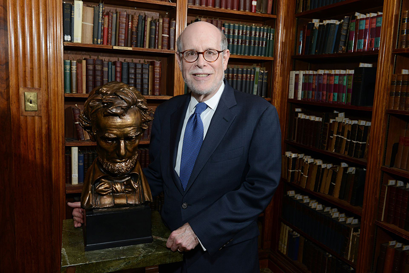 Harold Holzer stands in a library next to a bust of Abraham Lincoln.