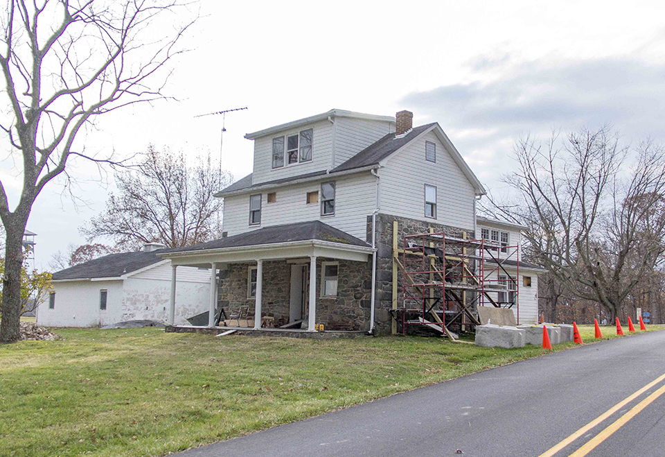 Selective demolition of modern additions at historic Warfield house to begin December 2. A three story house with stone first floor and white siding on the second and third floors is undergoing rehabilitation in an effort to restore it to its 1863 footprint.