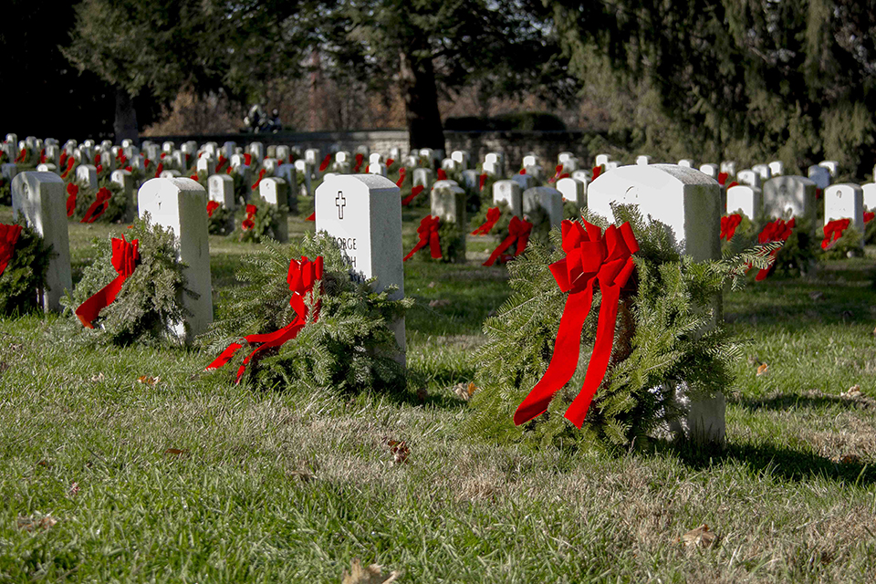 Holiday wreaths with large red bows adorn headstones in the Soldiers' National Cemetery.