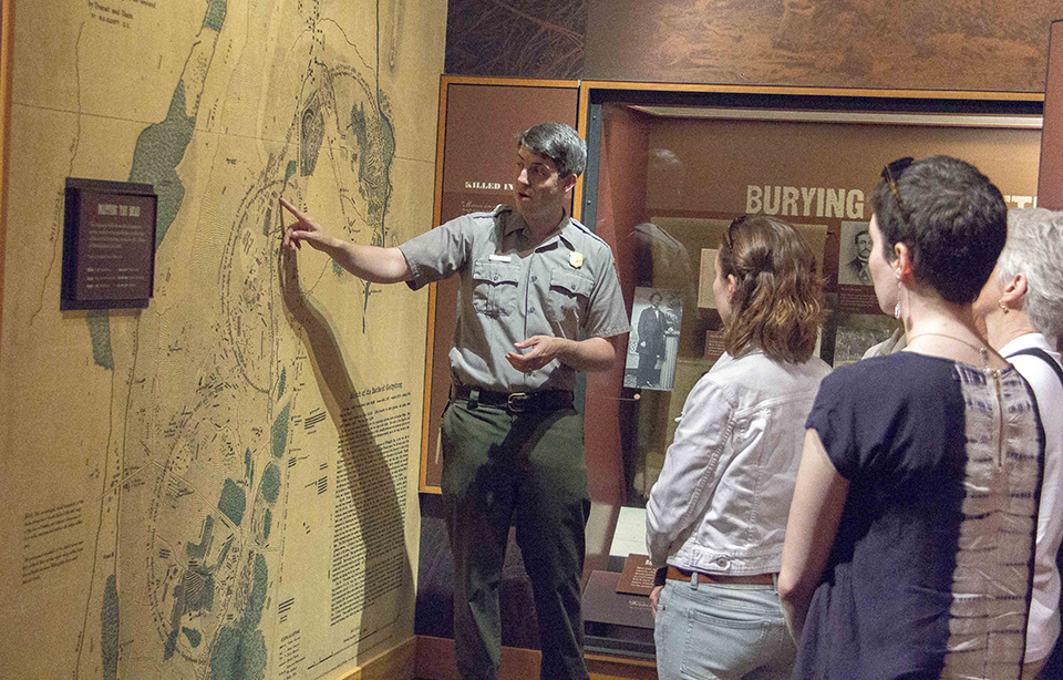 A park ranger speaks with visitors inside the museum.