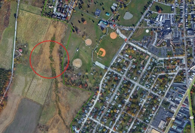 A satellite map of an area above the Gettysburg Area Recreation Park. There is a large red circle in an area of an adjacent field.