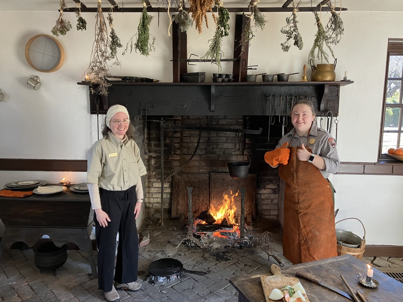 Park staff and volunteer demonstrating historic cooking techniques.