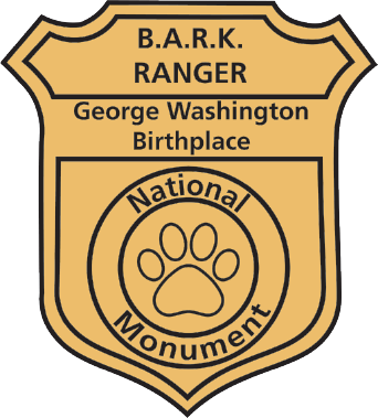 A yellow and black badge with text reading, "B.A.R.K. RANGER. George Washington Birthplace National Monument"