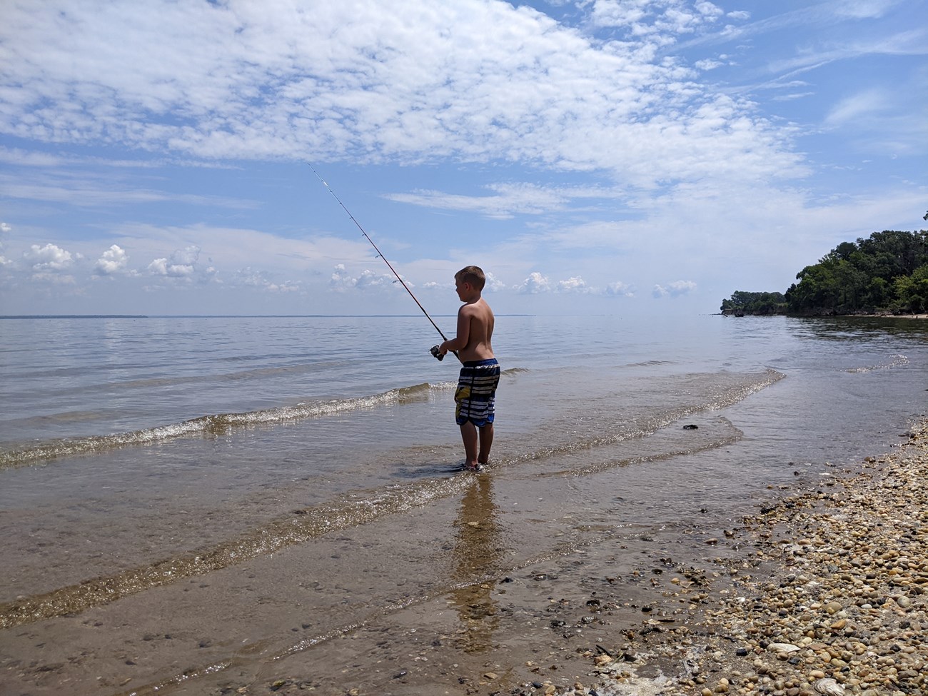 Youth fishing on sandy beach on the Potomac River