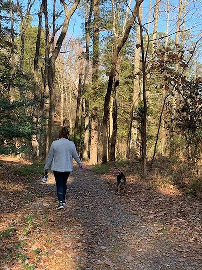 Park visitor and four-legged friend on nature trail