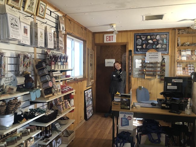 A Western National Parks Association employee poses in front of a door in the Gila Cliff dwellings Bookstore.