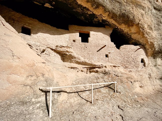 A view of cave 2 which has stone masonry construction and a t-shaped doorway built into the masonry construction.