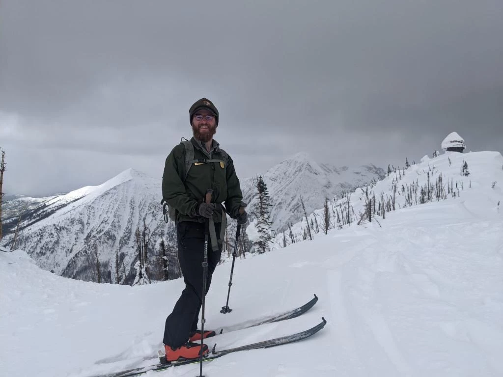 Park Ranger Cross Country Skiing A park ranger cross country skis on a snowy mountain