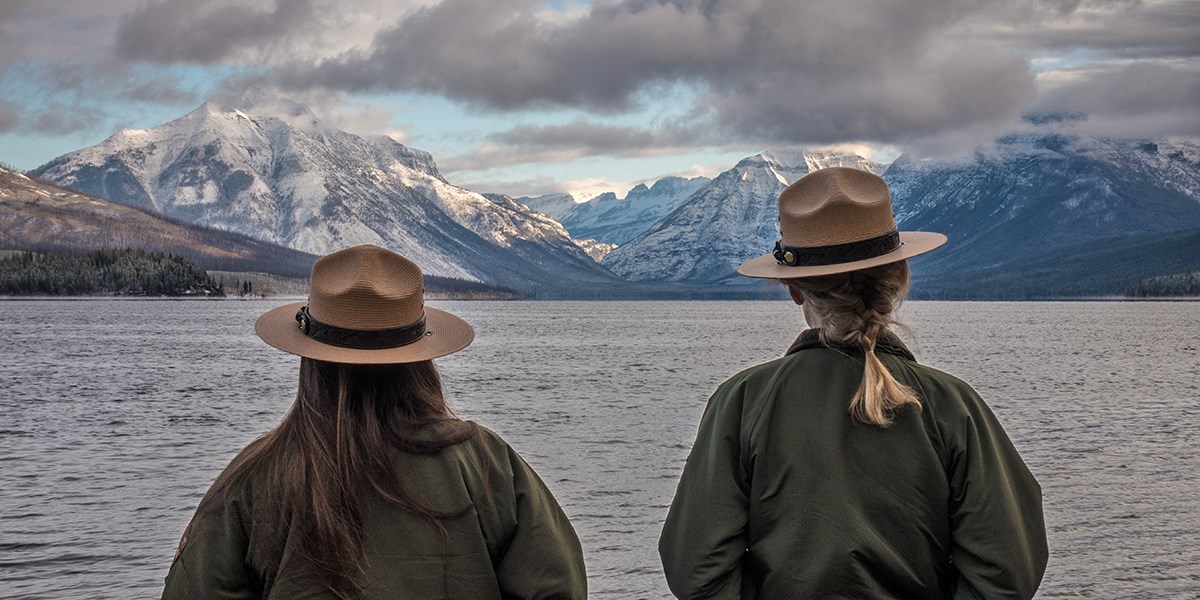 Two NPS employees look out over Lake McDonald