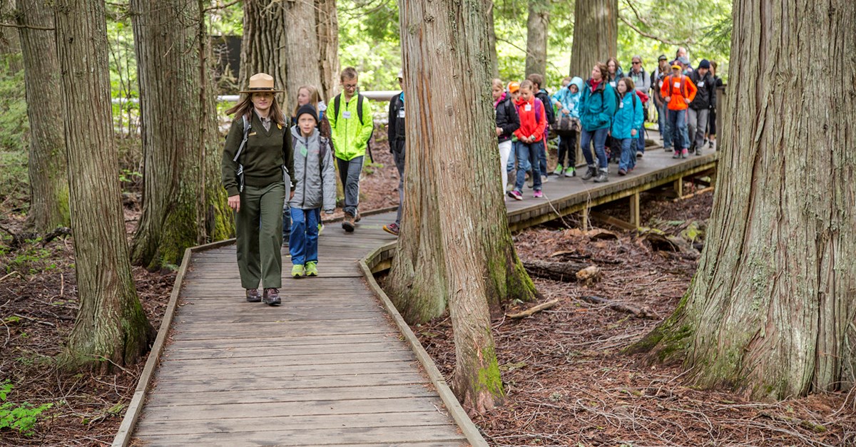 ranger leads line of children on boardwalk