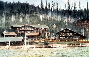 tinted historic slide of multiple wooden buildings adorned with antlers