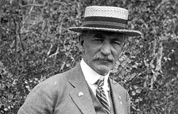 Headshot of man in three piece suit and boater hat