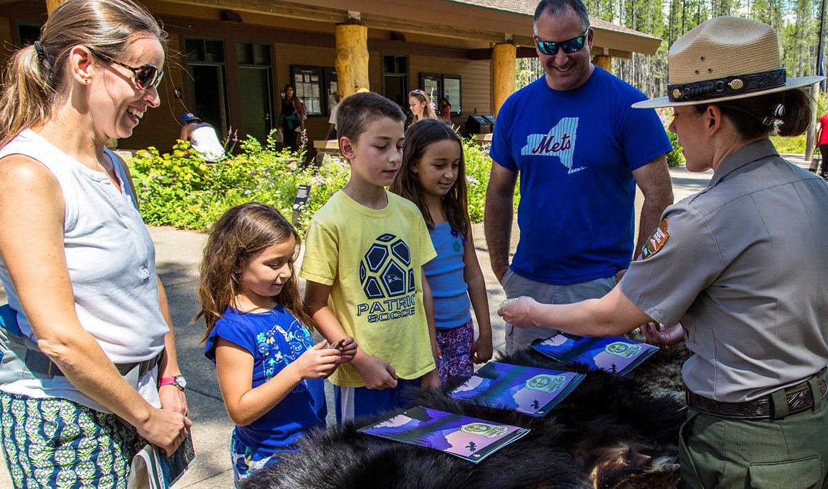 Three children accept badges from ranger Three children accept badges from ranger