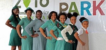 line of girls tallest to shortest, all wearing vintage girl scout uniforms