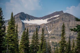 A landscape view of a mountain with a scooped recess where snow and ice is visible.