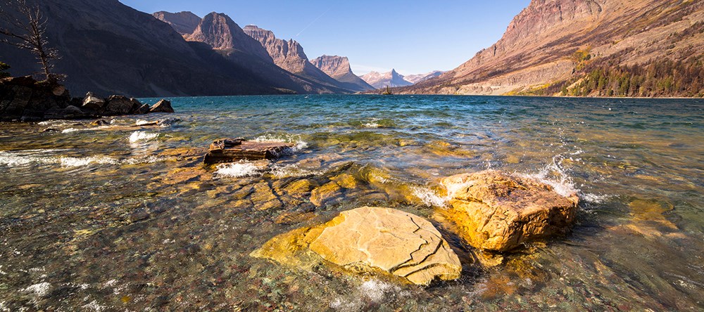 water splashes on rocks at mountain lake shoreline