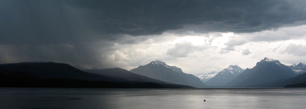 storm moving left to right over mountain lake