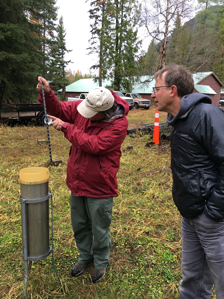 Scott Lang, Assistant Fire Effects Crew Leader, and Michael McClellan, Lead Fire Effects Specialist measure precipitation on the last day in October at the West Glacier COOP Weather Station. October was the rainiest month on record.